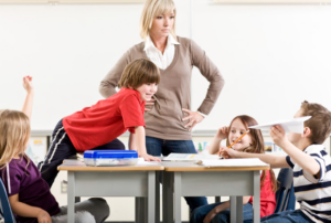 Lehrerin steht vor einer unruhigen Klasse
