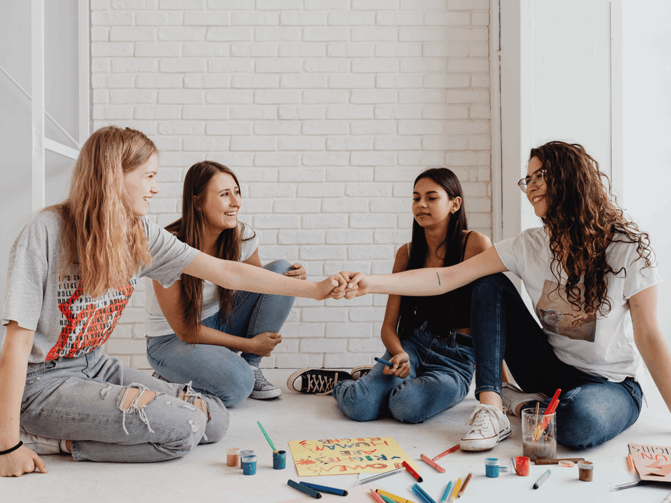 Eine Gruppe von Teenagern, die gemeinsam an einer kreativen Aufgabe arbeitet.