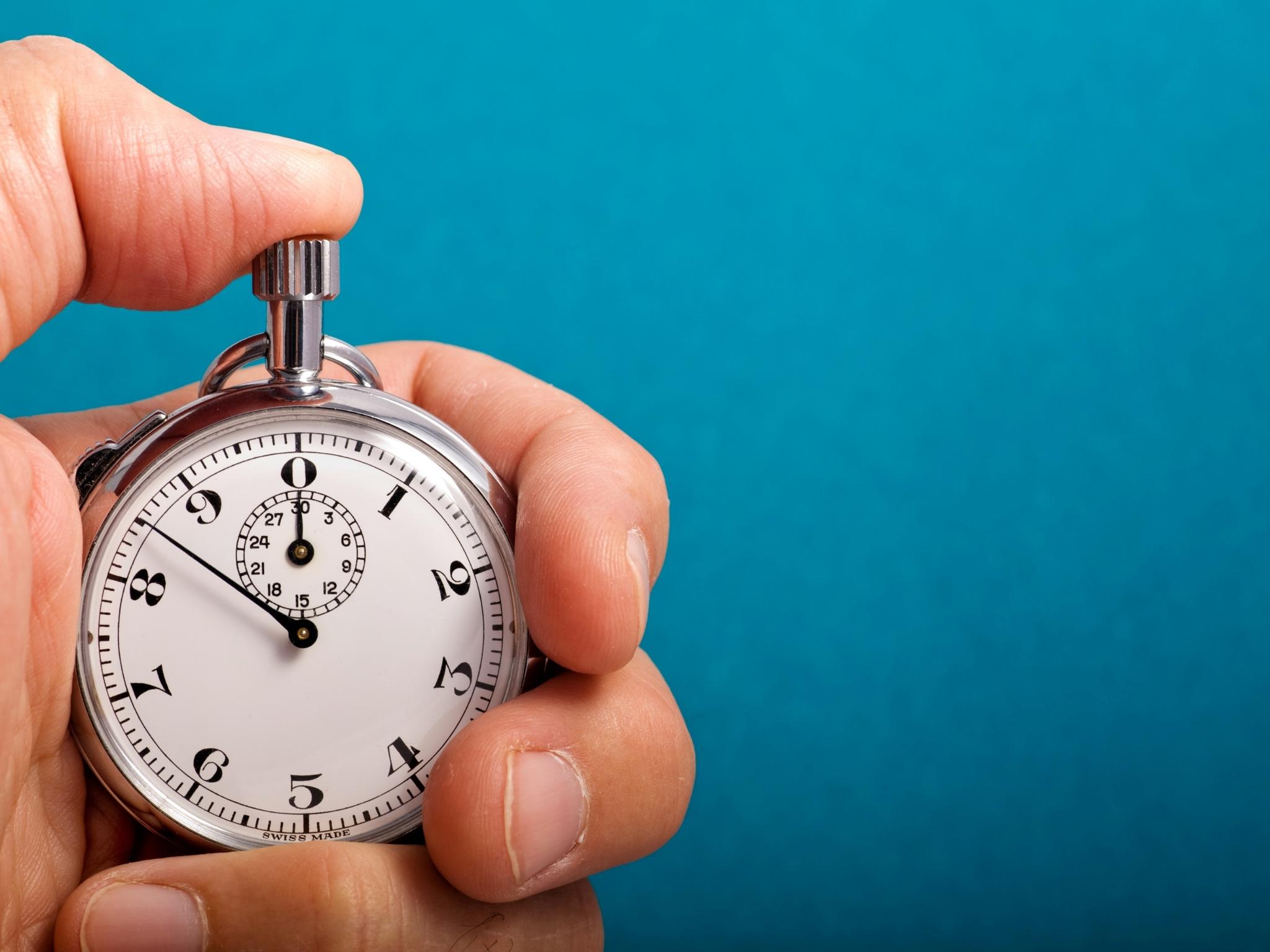 Hand hält Stoppuhr – KI-Impulse in unter einer Minute einsetzen.